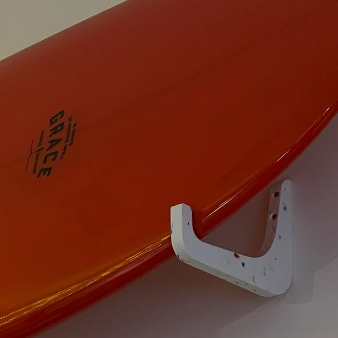 Rack de surf horizontal blanc EDERRAK en plastique recyclé avec une planche orange