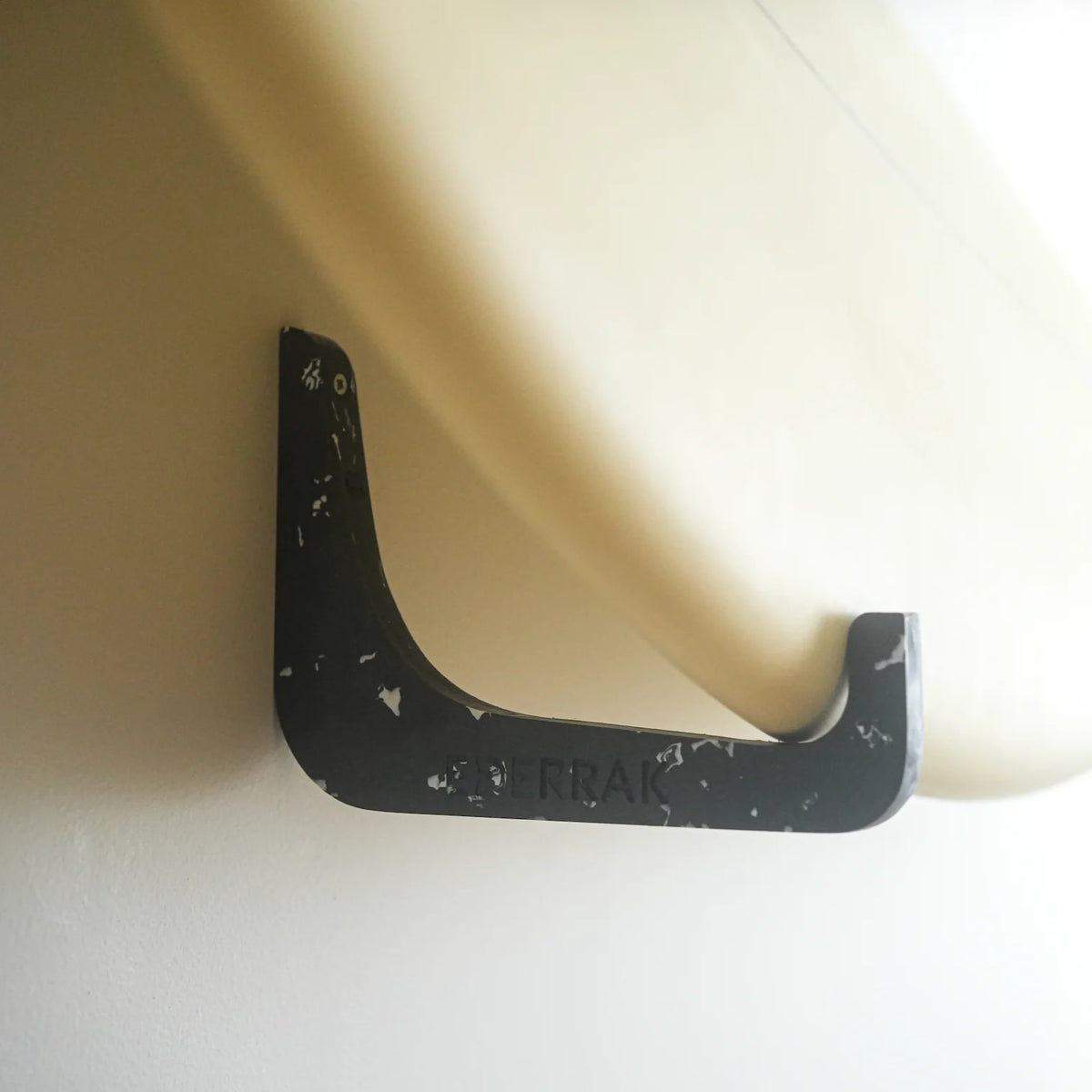 Rack de surf horizontal noir EDERRAK en plastique recyclé avec une planche au mur