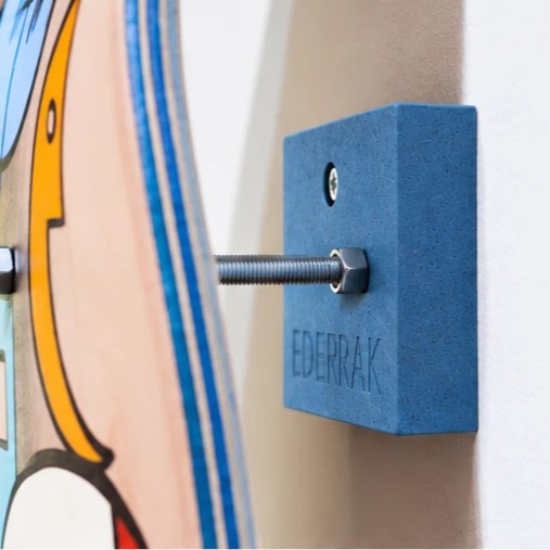 Support skate bleu EDERRAK en Valchromat fixé au mur avec un skateboard