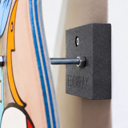 Support skate noir EDERRAK en Valchromat fixé au mur avec un skateboard