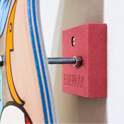Support skate rouge EDERRAK en Valchromat fixé au mur avec un skateboard