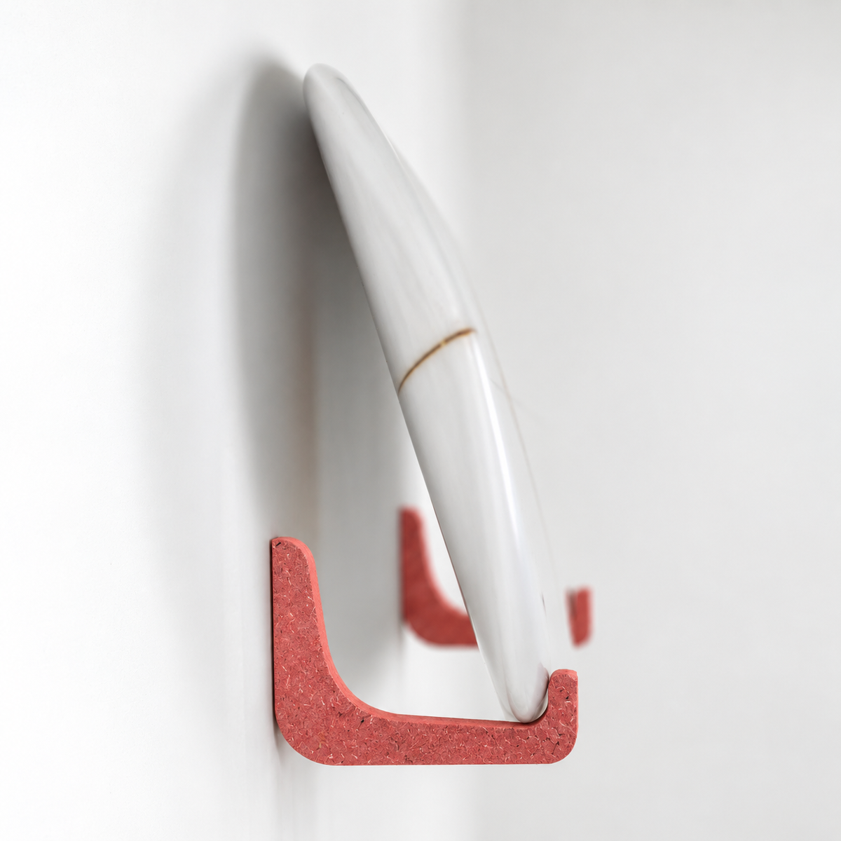 Rack de surf rouge en Valchromat, détail de l'équerre avec une planche de surf, fabriqué au Pays Basque - EDERRAK